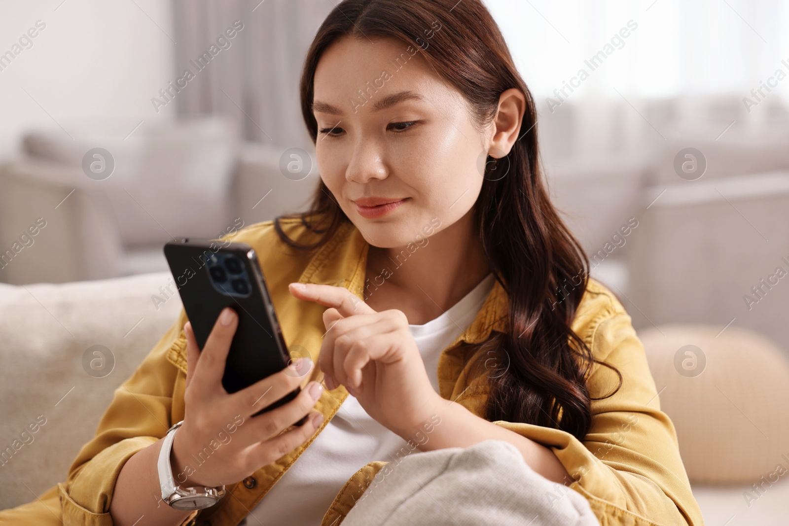 Photo of Portrait of beautiful woman with smartphone at home