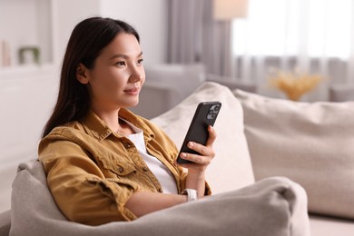 Portrait of beautiful woman with smartphone at home