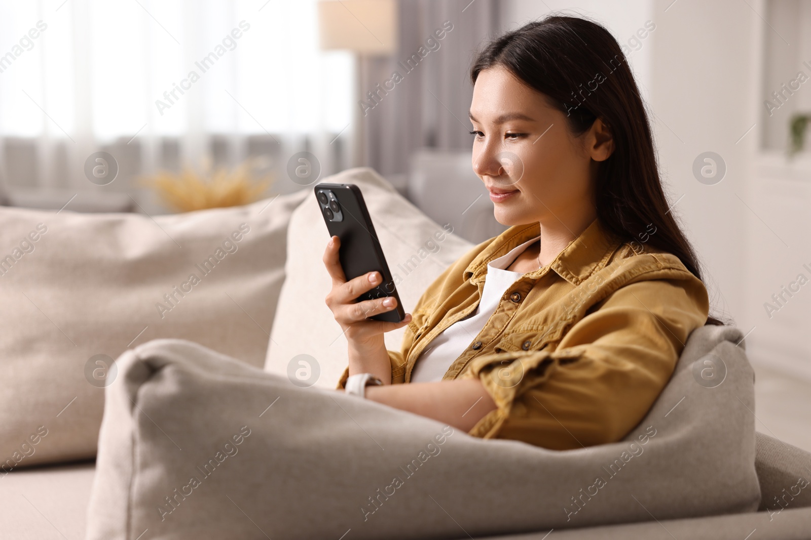 Photo of Portrait of beautiful woman with smartphone at home