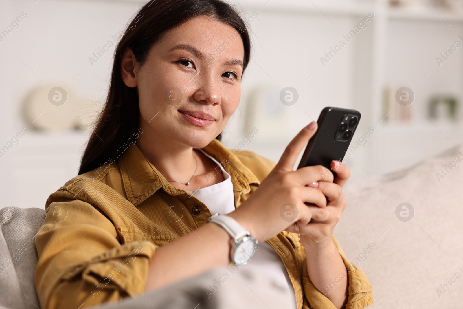 Photo of Portrait of beautiful woman with smartphone at home