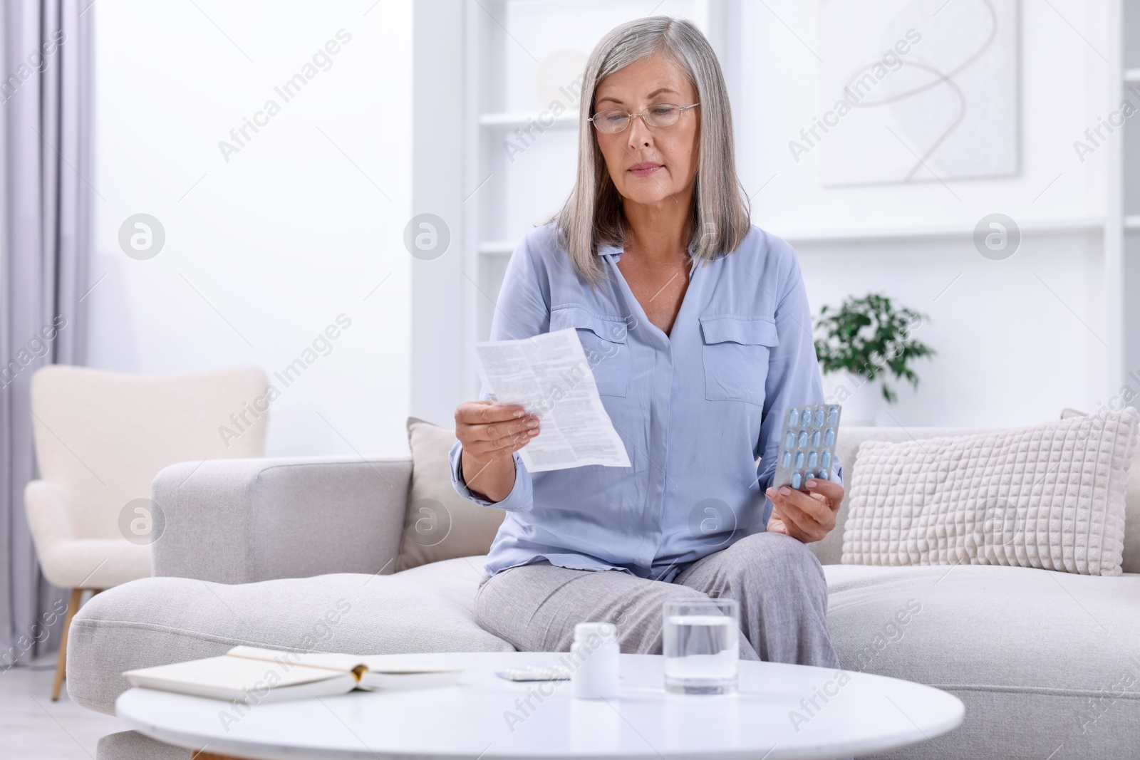 Photo of Senior woman with pills reading medicine instruction at home