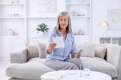 Senior woman with pills reading medicine instruction at home