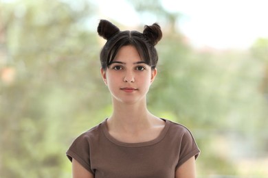 Portrait of beautiful teenage girl on blurred background