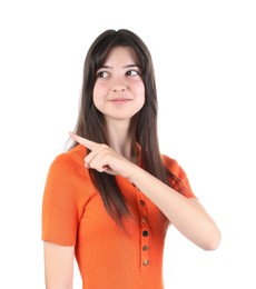 Portrait of cute teenage girl pointing at something on white background