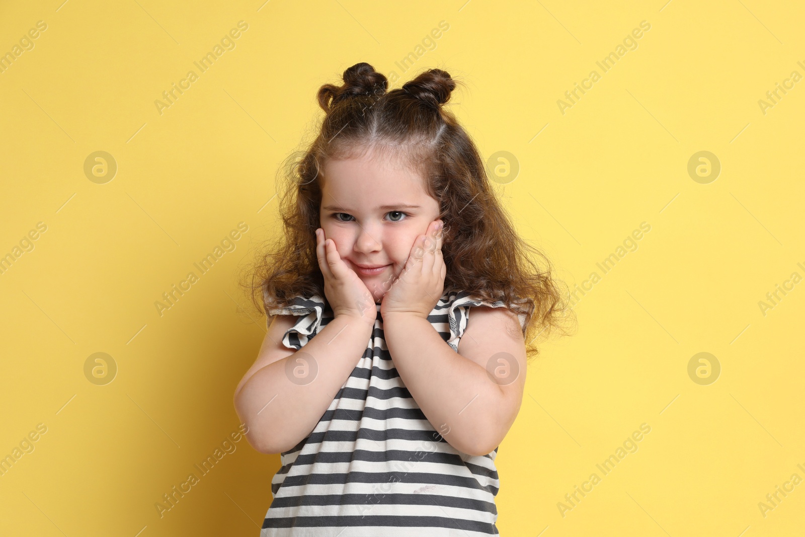 Photo of Portrait of cute girl on yellow background. Adorable child