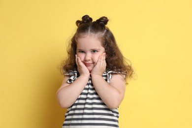 Photo of Portrait of cute girl on yellow background. Adorable child