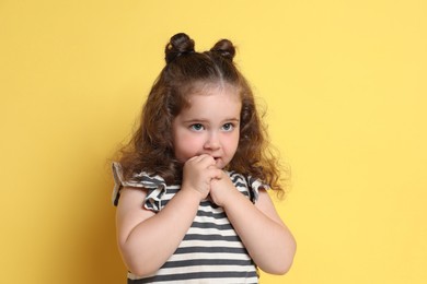 Photo of Portrait of cute girl on yellow background. Adorable child