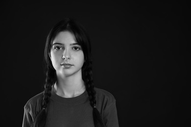 Photo of Portrait of teenage girl on dark background, space for text. Black and white effect