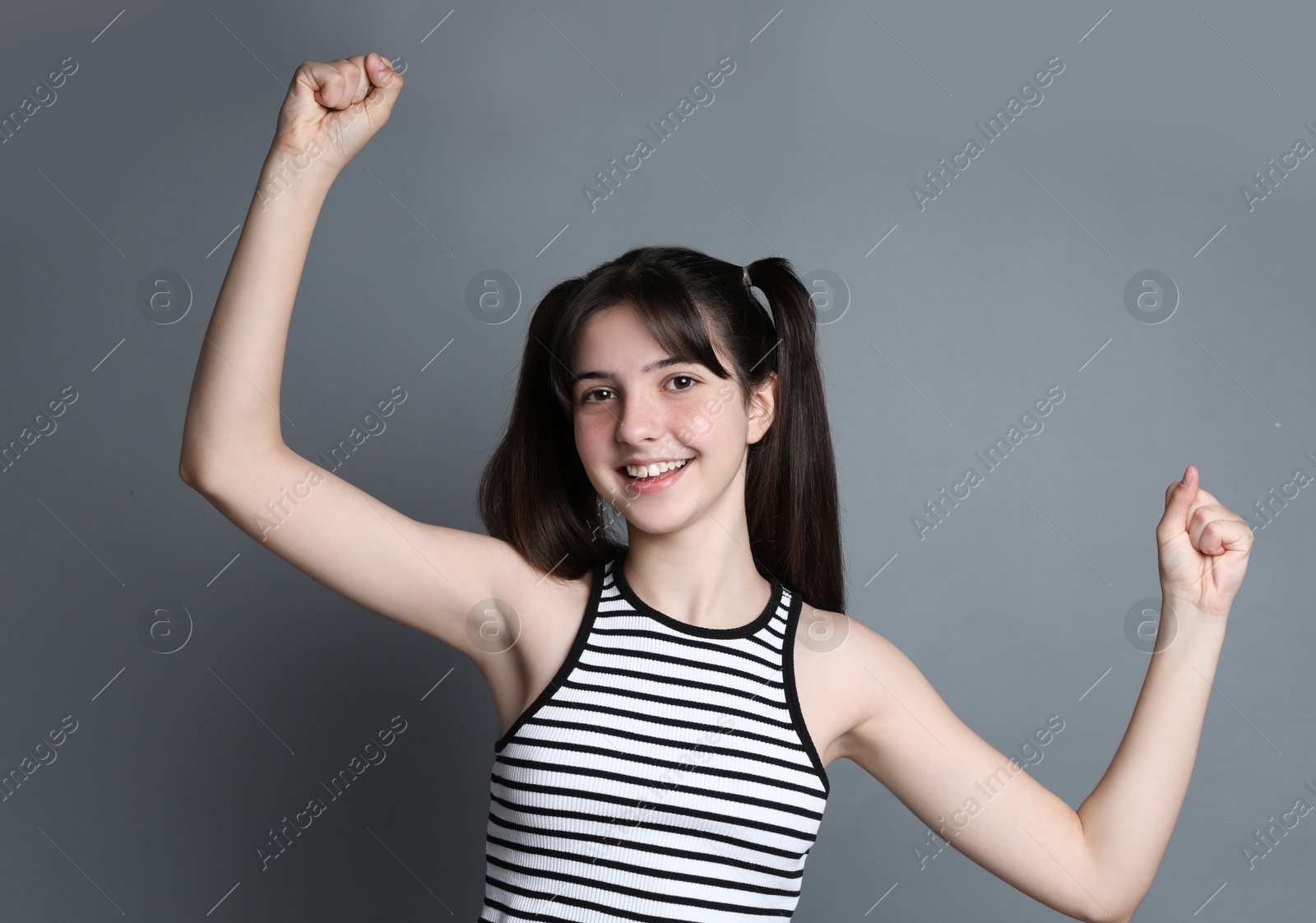 Photo of Portrait of smiling teenage girl on grey background