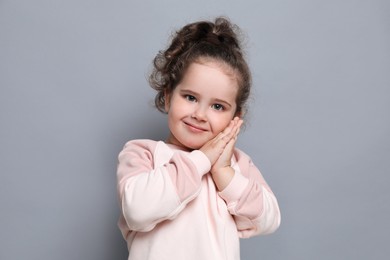 Photo of Adorable child. Portrait of cute girl on grey background