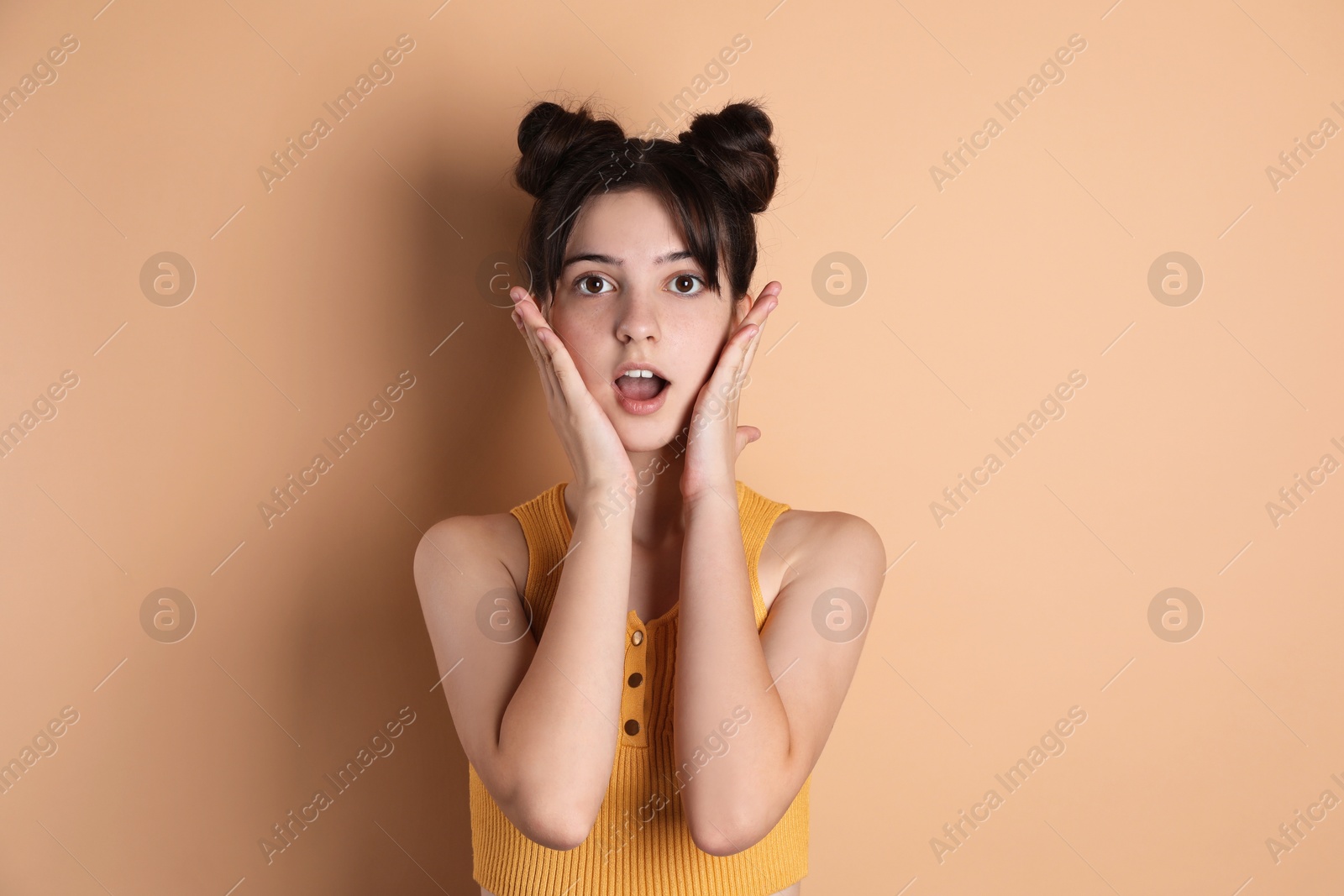 Photo of Portrait of surprised teenage girl on beige background