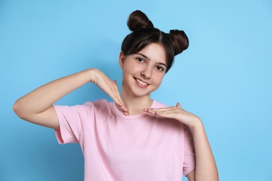 Photo of Portrait of smiling teenage girl on light blue background