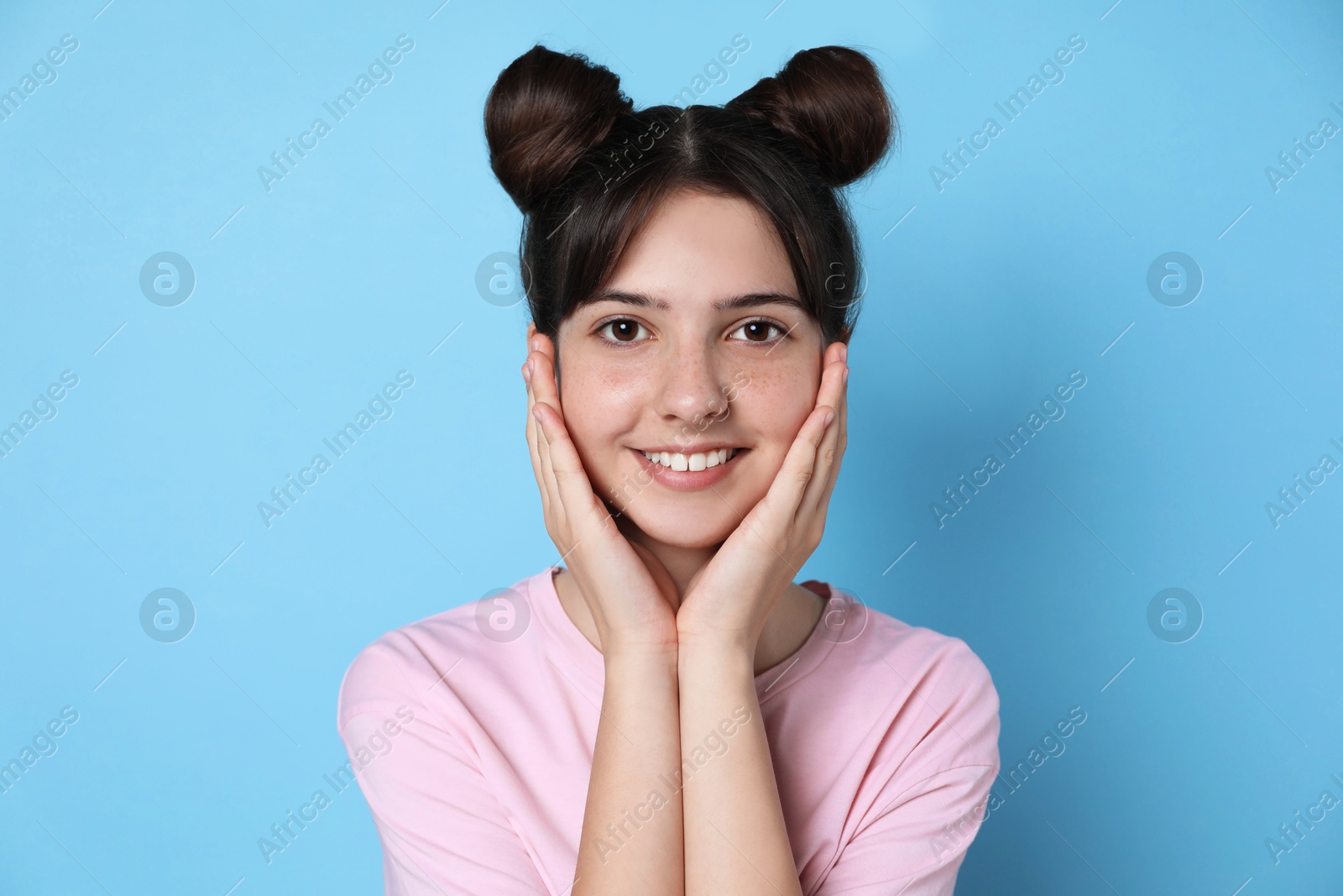 Photo of Portrait of smiling teenage girl on light blue background