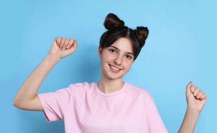 Photo of Portrait of smiling teenage girl on light blue background