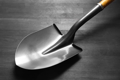 Photo of Metal shovel with handle on black wooden table