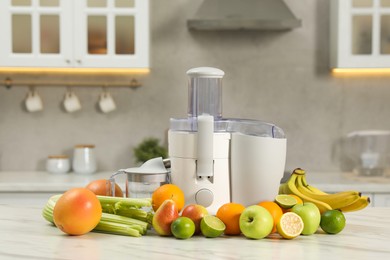 Photo of Modern juicer and fruits on white marble table