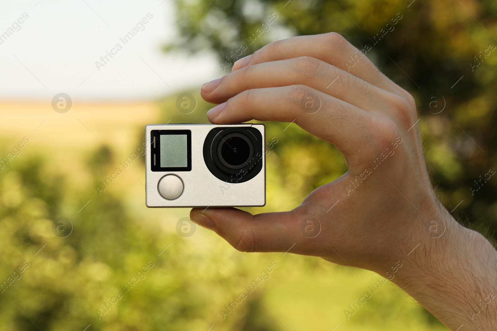 Photo of Man with modern action camera outdoors, closeup