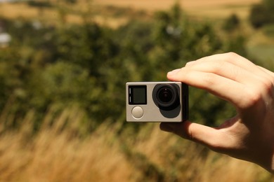 Photo of Man with modern action camera outdoors, closeup. Space for text