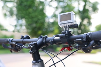 Modern action camera with mount on bicycle outdoors, closeup