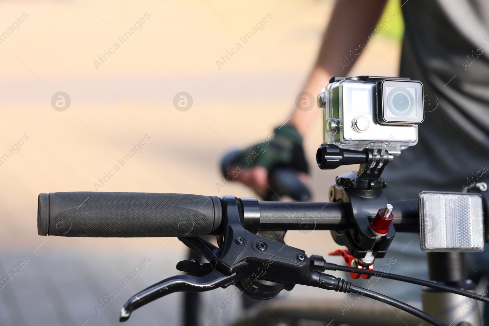 Photo of Man near bicycle with modern action camera outdoors, closeup