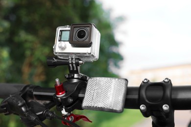 Modern action camera with mount on bicycle outdoors, closeup