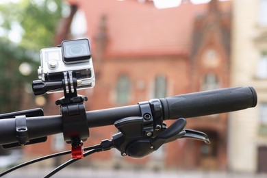 Modern action camera with mount on bicycle outdoors, closeup