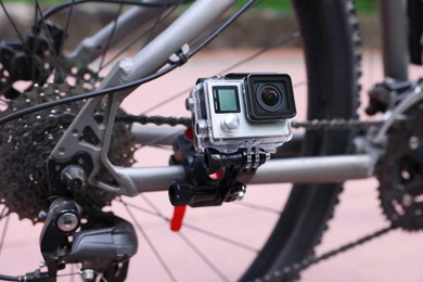 Modern action camera with mount on bicycle outdoors, closeup