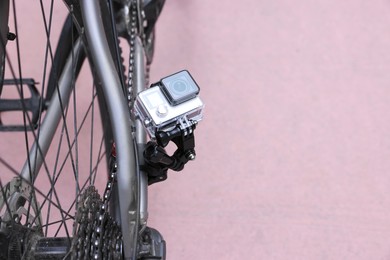 Modern action camera with mount on bicycle outdoors. Space for text