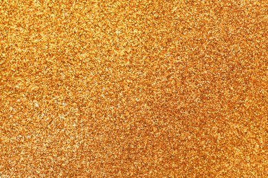 Photo of Shiny golden glitter as background, top view