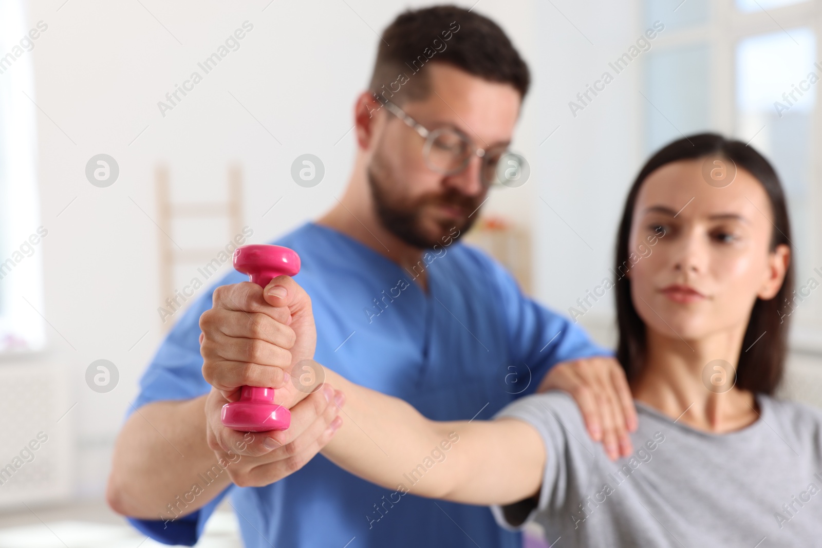 Photo of Patient exercising under physiotherapist supervision in rehabilitation center, selective focus