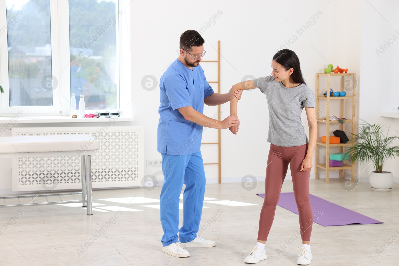 Photo of Physiotherapist working with patient in rehabilitation center