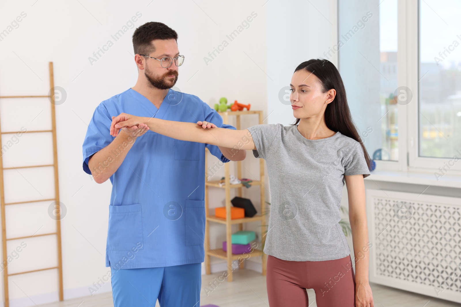 Photo of Physiotherapist working with patient in rehabilitation center