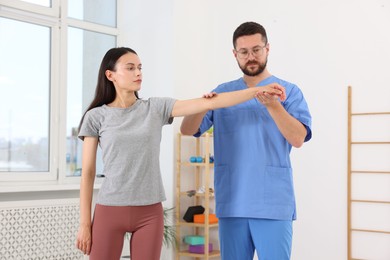 Photo of Physiotherapist working with patient in rehabilitation center