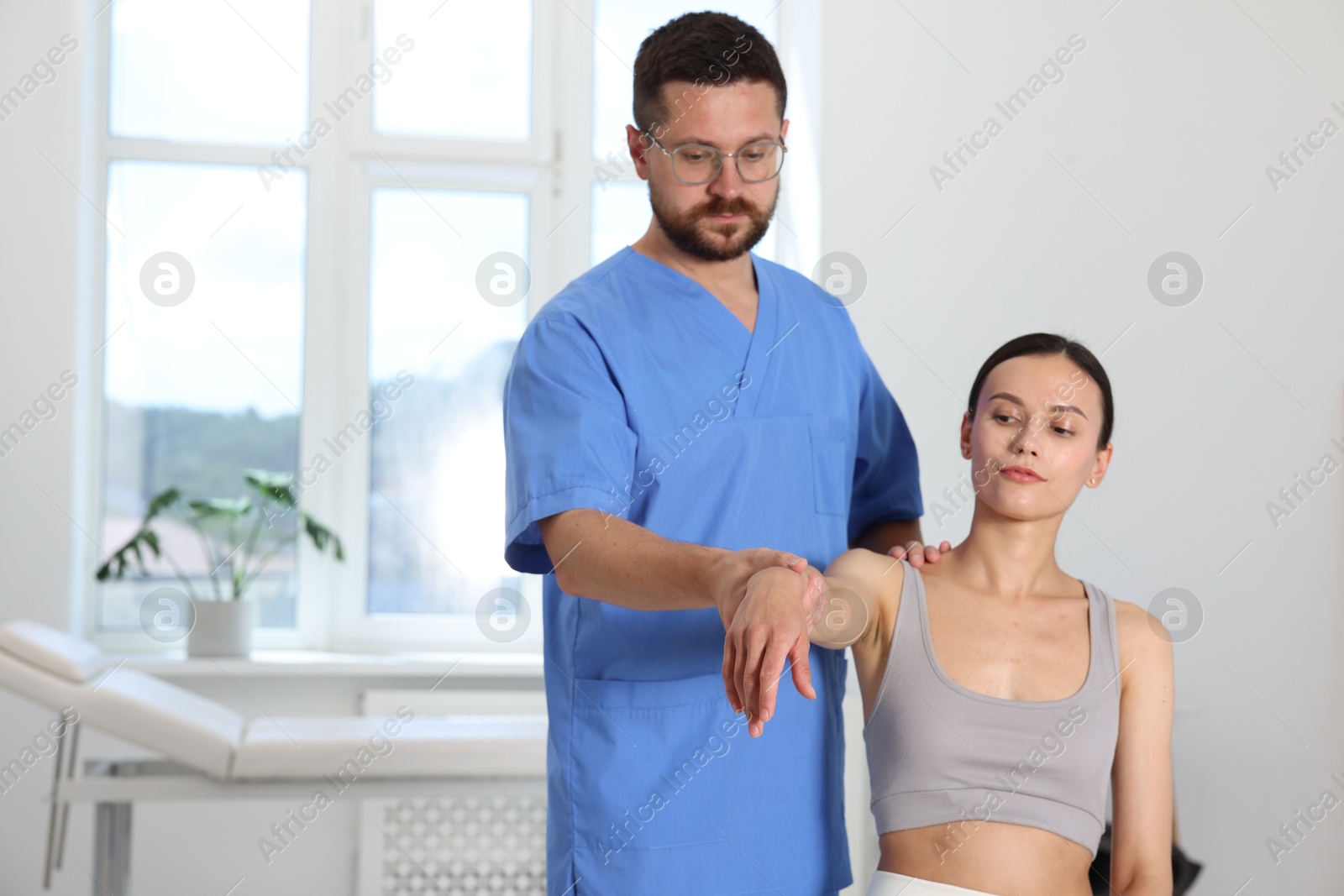 Photo of Physiotherapist working with patient in rehabilitation center