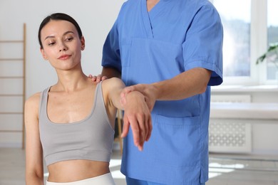 Photo of Physiotherapist working with patient in rehabilitation center