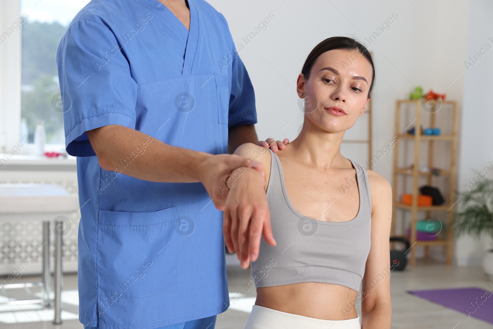 Photo of Physiotherapist working with patient in rehabilitation center