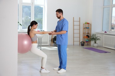 Photo of Physiotherapist working with patient in rehabilitation center