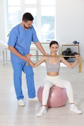 Patient exercising under physiotherapist supervision in rehabilitation center