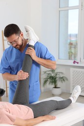 Photo of Physiotherapist working with patient in rehabilitation center