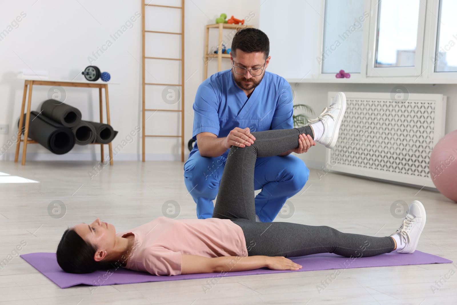 Photo of Physiotherapist working with patient in rehabilitation center