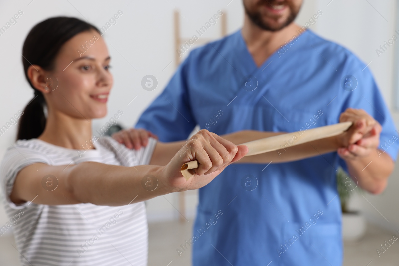 Photo of Patient exercising under physiotherapist supervision in rehabilitation center, selective focus