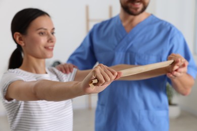 Patient exercising under physiotherapist supervision in rehabilitation center, selective focus