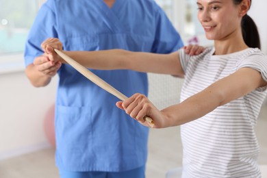 Patient exercising under physiotherapist supervision in rehabilitation center, selective focus