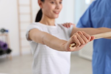 Patient exercising under physiotherapist supervision in rehabilitation center, selective focus