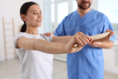 Photo of Patient exercising under physiotherapist supervision in rehabilitation center, selective focus