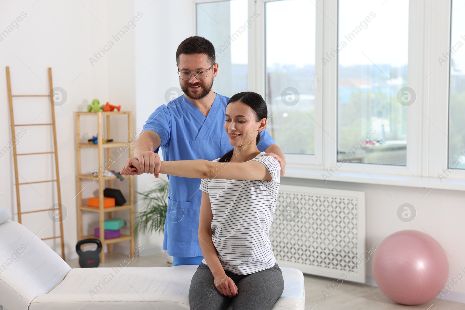 Photo of Physiotherapist working with patient in rehabilitation center