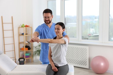 Photo of Physiotherapist working with patient in rehabilitation center