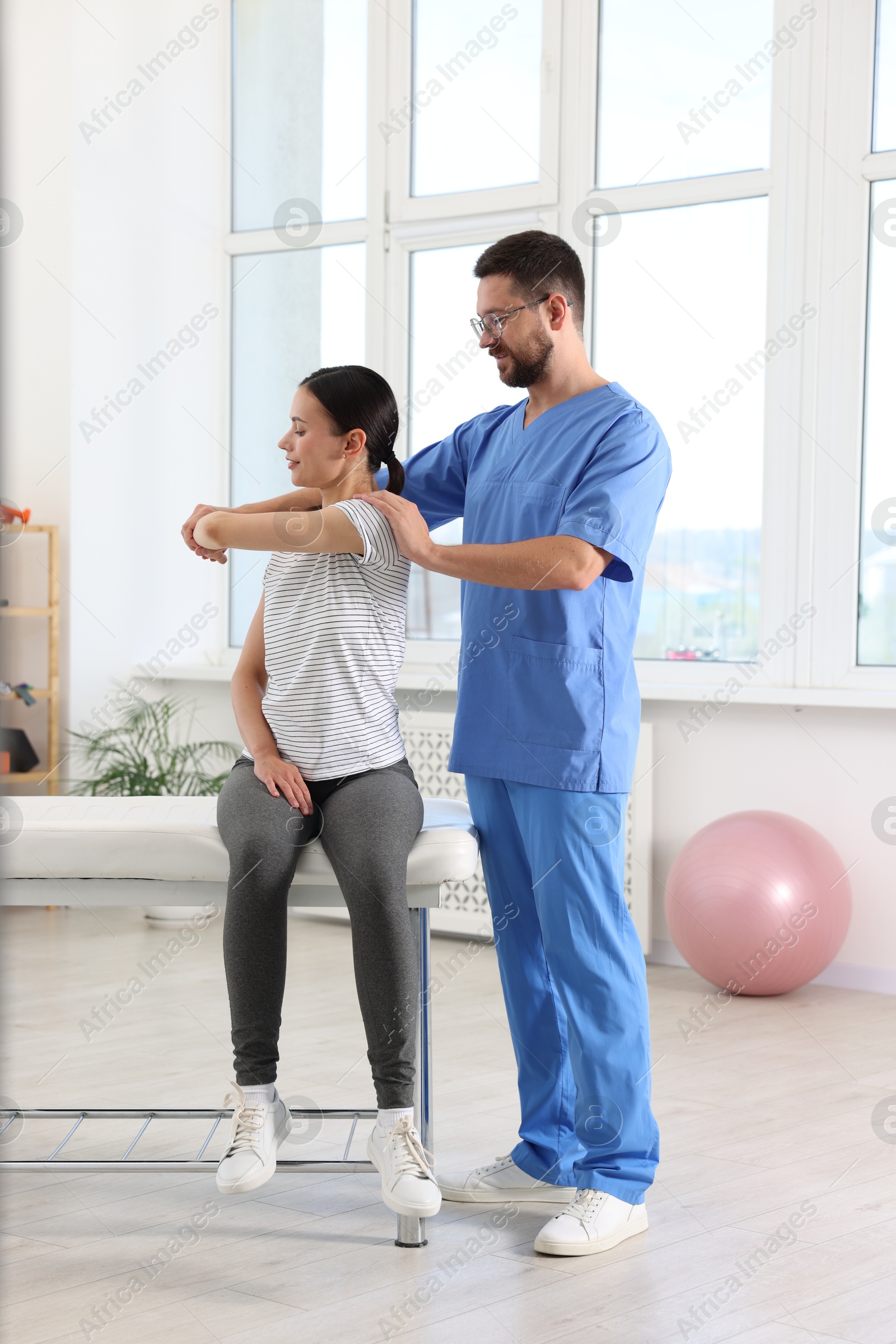 Photo of Physiotherapist working with patient in rehabilitation center