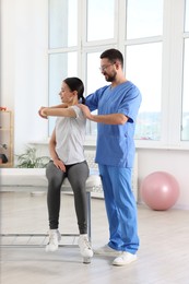 Photo of Physiotherapist working with patient in rehabilitation center