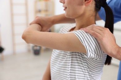 Physiotherapist working with patient in rehabilitation center, closeup